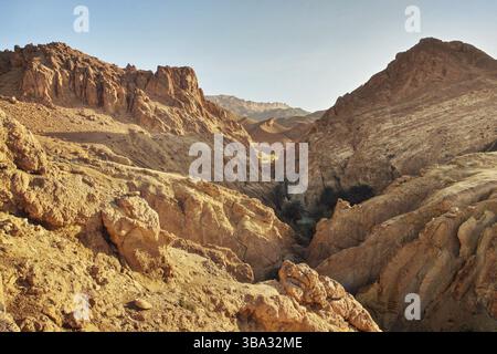 Trockene Felsen in der Wüste, beleuchtet von der Mittagssonne. Chebika-Oase, Atlasgebirge, Tunesien, Afrika Stockfoto