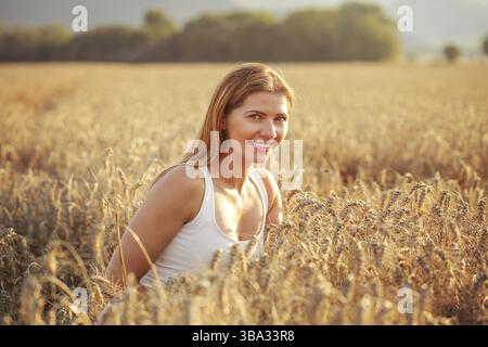 Young woman in wheat field lit by afternoon sun, Liptovsky Hradok, Slovakia, Europe Stockfoto