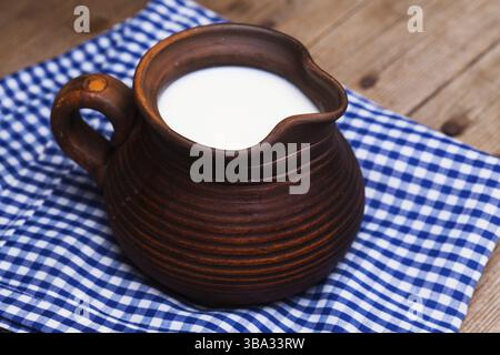 Tonkrug voll Milch in rustikalem Stil Stockfoto