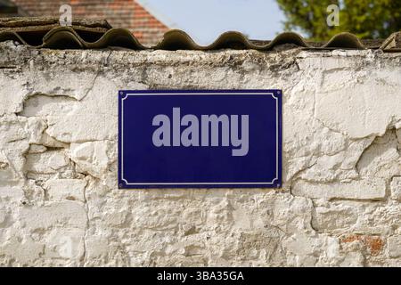 Leeres Straßennamenschild als Kopierraum an der alten Ziegelwand Stockfoto