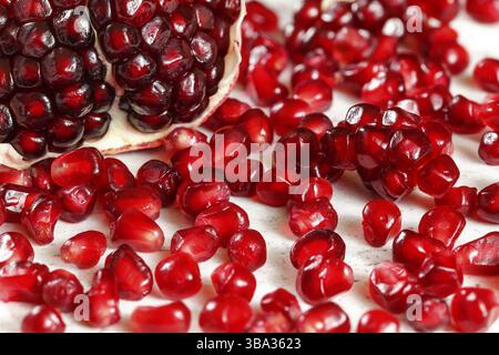 Nahaufnahme - hellrotes Juwel wie Granatapfelkerne mit einer Hälfte Frucht im Hintergrund, Liptovsky Hradok, Slowakei, Europa Stockfoto