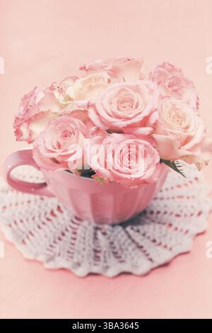 Ein Strauß wunderschöner, frischer rosa Rosen in einem pinken Becher Stockfoto