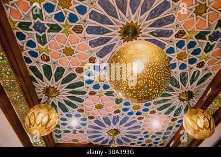 9. März 2025, Marrakesch, Marokko: Wunderschöne Decke mit einem raffinierten geometrischen Muster im arabischen Stil mit Hängelampen und Spots Stockfoto