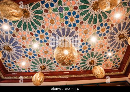 9. März 2025, Marrakesch, Marokko: Wunderschöne Decke mit einem raffinierten geometrischen Muster im arabischen Stil mit Hängelampen und Spots Stockfoto