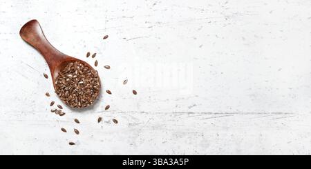 Kleine Holzlöffel mit Leinsamen - Linum usitatissimum, auf weißem Stein wie Schreibtisch, Blick von oben, Platz für Text rechts, Liptovsky Hradok, SL Stockfoto