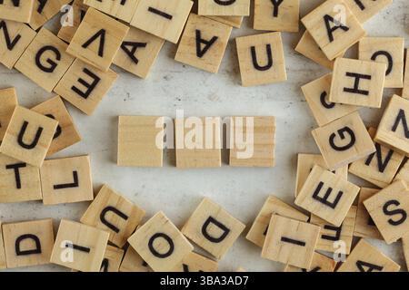 Ansicht von oben nach unten, Stapel quadratischer Holzblöcke mit Buchstaben auf Weißtafel. Drei leere Kacheln für Ihren Text, Liptovsky Hradok, Slowakei, Europa Stockfoto
