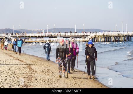Polen, Sopot, 9. Februar 2020. Leute am Strand in Sopot. Menschenmenge am Strand im Winter. Genießen Sie den Tag im sonnigen Winter in der Nähe des Meeres. Menschen, die entlang laufen o Stockfoto