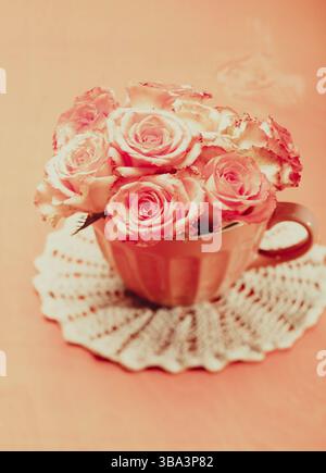 Ein Strauß wunderschöner, frischer rosa Rosen in einem pinken Becher Stockfoto