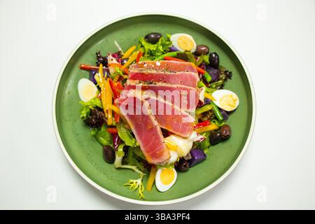 Traditioneller Thunfischsalat mit Kartoffeln, Oliven, Bohnen, Eiern und Salat mit weißem Hintergrund Stockfoto