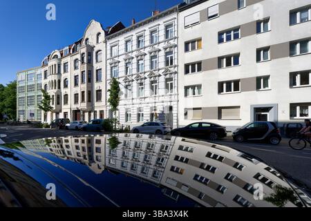 Fassaden von Altbauten spiegeln sich auf einem Autodach in der Vogelsanger Straße in Köln Ehrenfeld Stockfoto