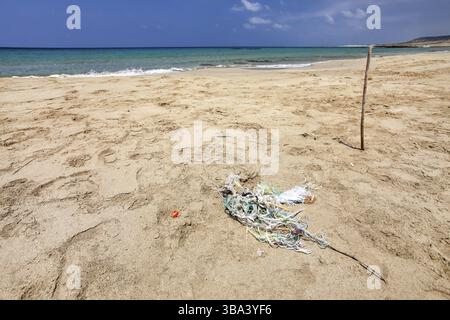 Perfekte leer unberührten Strand, kleine Haufen Müll (tangled Kunststoff Seile) auf feinem Sand, mit ruhigem Meer im Hintergrund. Ozean littering Konzept. Karpass, N Stockfoto