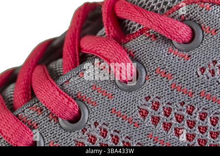 Ein Fragment eines grau Sneaker mit rosa Spitzen hautnah. Sneaker Textur Stockfoto