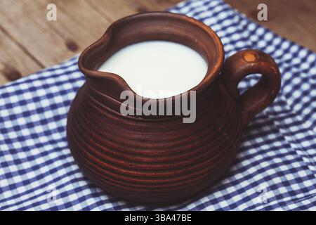 Tonkrug voll Milch in rustikalem Stil Stockfoto