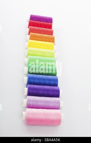 Mehrfarbige Fäden werden isoliert auf weißem Hintergrund vernäht Stockfoto