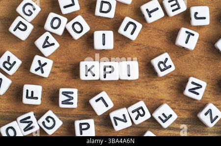 Kleine weiße und schwarze Perlenwürfel auf Holzbrett, Buchstaben in Mittelbuchstaben KPI - Key Performance Indicators Concept, Liptovsky Mikulas, Slowakei, Europ Stockfoto