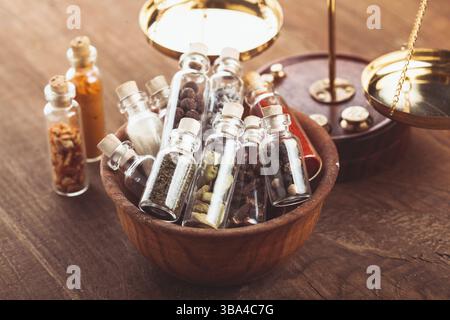 Kleine Flaschen mit Gewürzen in einer Holzschale in der Küche. Retro-Dekorationen Stockfoto