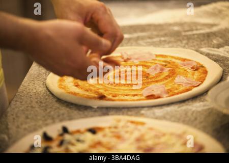 Pizza im Restaurant machen, Hände vom Koch aus der Nähe Stockfoto