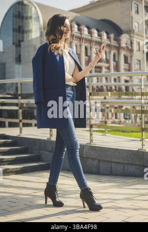 Bürogebäude Stadt Leute in Anzug. Kaukasische Geschäftsfrau mit Smartphone mit Hand. Geschäftskonzept. Portrait stilvolle Business woman in Mode Stockfoto