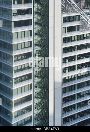 Modernes hohes Stahl- und Glas Buerogebaeude, Nahaufnahme Detail zu normalen Fenstern, Treppe sichtbar Stockfoto