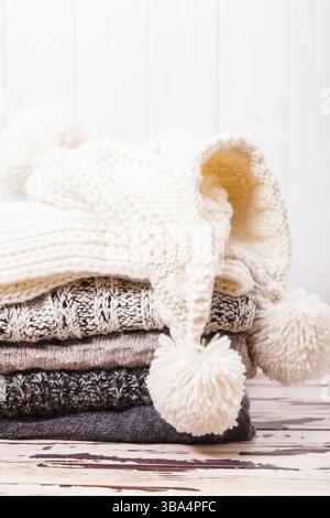 Gestalte warme Strickpullover, Schal und Mütze in Weiß und Grau Stockfoto