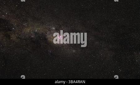 Südlicher Nachthimmel, viele Sterne mit Milchstraße um Crux und Vela Konstellation, rot lila Great Carina Nebel in der Mitte sichtbar Stockfoto