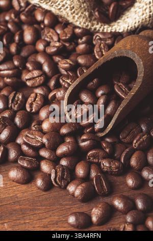 Die ausgelaufenen Bohnen auf dem Tisch und der Holzlöffel Stockfoto