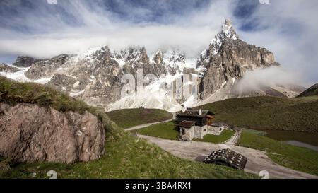 Cimon della Pala (auch Matterhorn der Dolomiten genannt) mit schneebedeckten Gipfeln an einem sonnigen Tag mit dramatischen Wolken darüber. San Martino di Castr Stockfoto