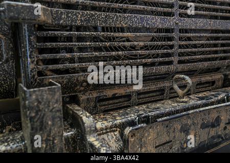 Front des militaerischen 4wd-Fahrzeuge, Metallgitter mit trockenem Schlamm und Rost, Nahaufnahme Detail Stockfoto