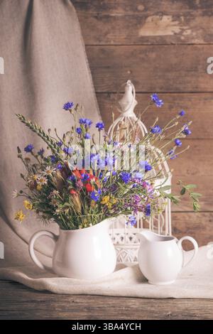Wildblumen in weißer Keramik Krug und Tassen auf Tablett Stockfoto