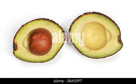 Reife Avocado (Sorte hass oder bilse) in Hälften geschnitten, mit gelbgrünem Fruchtfleisch, Samen in einer Hälfte, Ansicht von oben isoliert auf weißem Hintergrund, Li Stockfoto