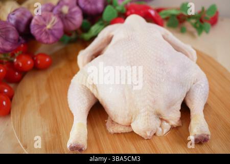 Rohes Hühnchen mit frischem Gemüse auf Holzschneidebrett Stockfoto