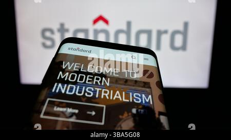 In dieser Abbildung ist ein Mobiltelefon mit der Webseite des US-amerikanischen Unternehmens Standard Industries Inc. Auf dem Bildschirm vor dem Logo zu sehen. Stockfoto