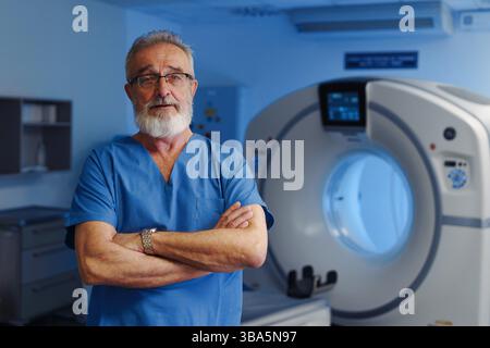 Medizinischer Spezialist steht neben dem CT-Scanner, Blick auf die Kamera, Krankenhausumgebung. Stockfoto