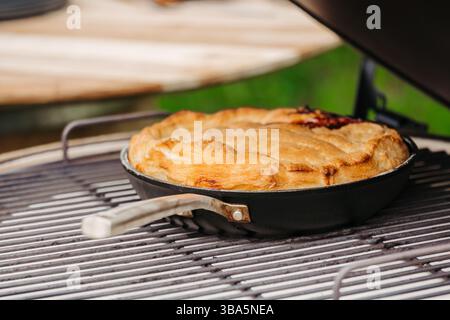 Hausgemachter Apfelkuchen, gebacken in einer Pfanne auf einem Grill im Freien Stockfoto