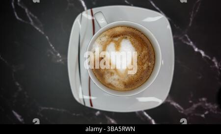 Tasse Cappuccino mit Herz Latte Art auf schwarzem Hintergrund Stockfoto