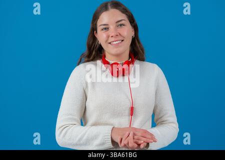 Porträt fröhliche junge Frau lächelt mit roten Kopfhörern um den Hals Stockfoto