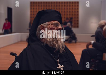 Lebensechte Skulptur eines älteren Ordensmannes mit großem Kreuz in der Kunstinstallation "Old Persons Home" Stockfoto