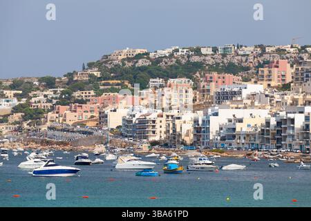 Mellieha, Malta - 29. August 2019: Eine malerische Küstenstadt im Mittelmeer mit farbenfrohen Gebäuden, malerischer Küste und vor Anker liegenden Booten Stockfoto