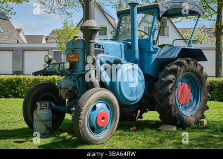 20. April 2025 – Limmen-Niederlande: Restaurierter blauer Lanz Bulldog-Traktor mit roten Rädern während der jährlichen Rallye-Veranstaltung Bloemendagen in Limmen. Stockfoto