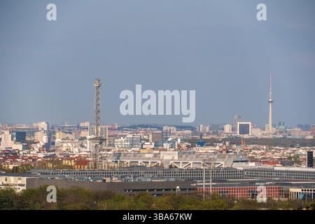 Ein hoher Gitterfunkmast steht vor einer Panoramaaussicht vom Teufelsberg über die Berliner Skyline und den Fernsehturm, Berlin, Deutschland. Stockfoto