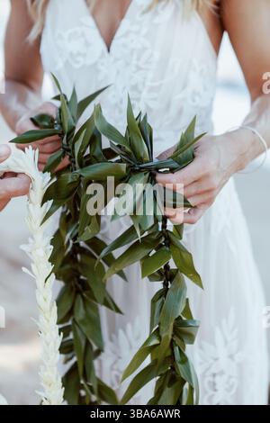 Jungvermählte halten hawaiianische Lei in Beach Elopement Stockfoto
