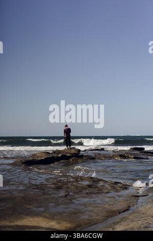 Ein Mann, der den Wind am Strand genießt Stockfoto