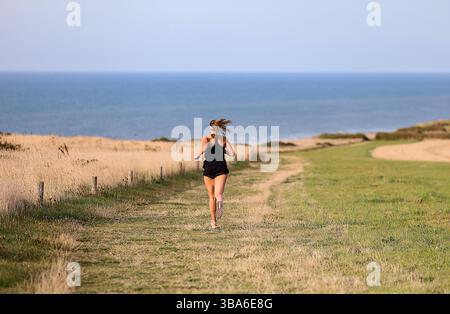 Sangatte, Küstengebiet „Côte d'Opale“ (Nordfrankreich): Frau, die entlang der Küste läuft Stockfoto