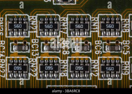 Ein Makrofoto, das elektronische Komponenten sorgfältig auf einer Leiterplatte zeigt. Das Bild zeigt das komplizierte Design, einschließlich Widerständen Stockfoto