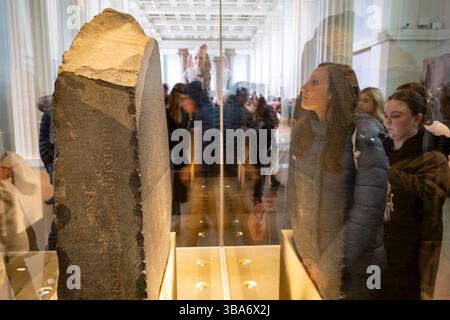 Besucher, die am 25. März 2025 in London, Großbritannien, den Rosetta Stone im British Museum besichtigen und fotografieren. Das British Museum ist ein öffentliches Museum, das sich der Geschichte, Kunst und Kultur der Menschheit widmet und sich im Londoner Viertel Bloomsbury befindet. Sie verfügt über eine permanente Sammlung von acht Millionen Werken und gehört zu den größten und umfassendsten Sammlungen, die die Geschichte der menschlichen Kultur von ihren Anfängen bis zur Gegenwart dokumentieren. Stockfoto