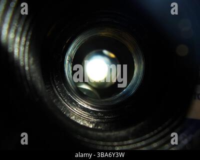 Nahaufnahme im Inneren des Fernglases, die innere Linse und Lichtreflexionen erfasst. Abstrakte Komposition, Kreissymmetrie, Optik. Stockfoto