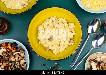 Traditioneller ukrainischer Hirsebrei mit Pilzen in einer Keramikschale. Draufsicht. Stockfoto