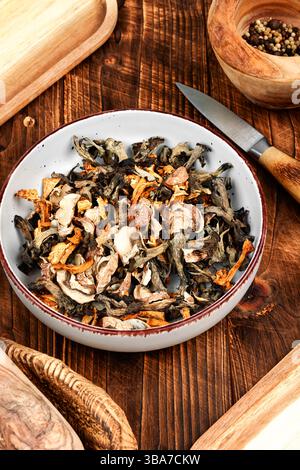 Eine lebhafte Auswahl an getrockneten Pilzen auf einem rustikalen Holztisch Stockfoto