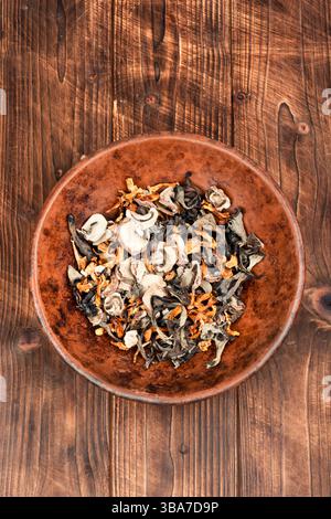 Eine lebhafte Auswahl an getrockneten Pilzen auf einem rustikalen Holztisch Stockfoto