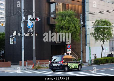TOKIO, JAPAN - 8. Mai 2025: Ein Taxi fährt am Shizuoka Press and Broadcasting Center im Zentrum von Tokio vorbei. Stockfoto
